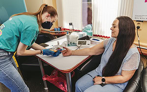 A volunteer checking a person's vitals.
