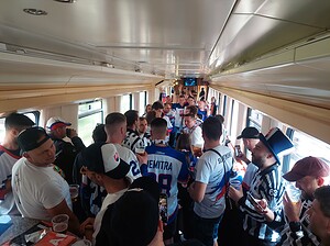 A carriage full of hockey fans wearing their teams jerseys. 